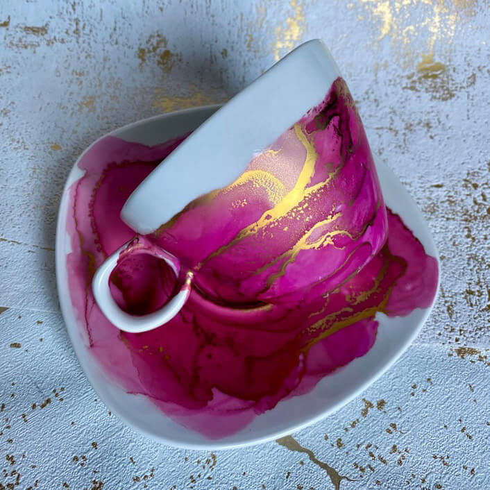 Filiżanka i spodek ceramiczny zdobione w technice alkohol inks w czasie Warsztatów Artystycznych w Pracowni Kreatywności